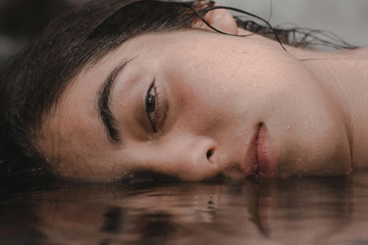 Un volto, con il lato destro immerso nell'acqua